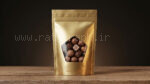 موکاپ پاکت لوکس خشکبار و شکلات طلایی با پنجره پنج‌ضلعی روی میز چوبی
